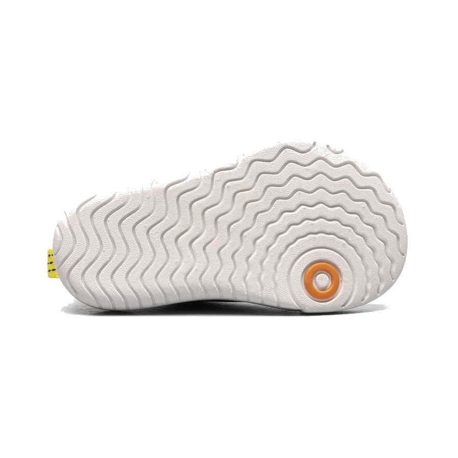 White textured outsole of a Bogs shoe with an orange circular detail, designed for easy on and off.