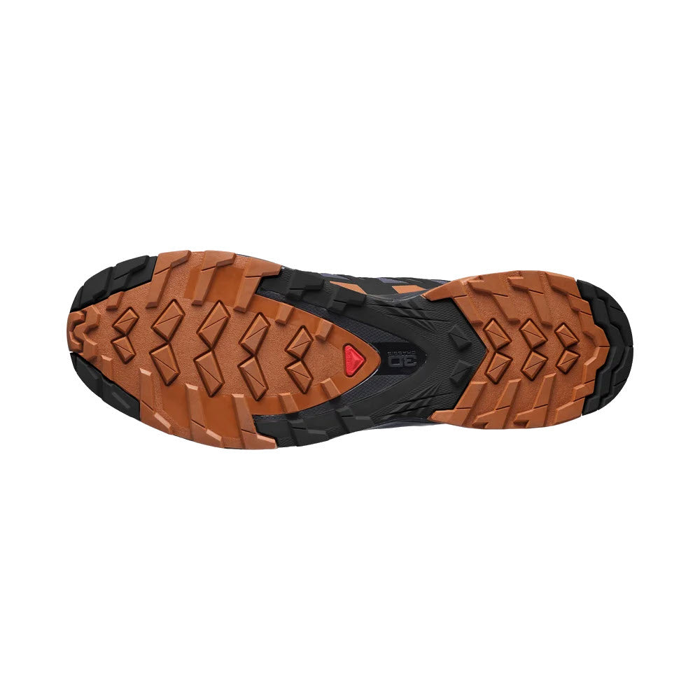 Bottom view of a SALOMON XA PRO 3DV8 GTX EBONY/CARAMEL CAFE/BLACK - MENS hiking boot sole with deep tread and brown rubber, featuring a distinctive black and red logo at the center, crafted from Contagrip® premium wet compound.