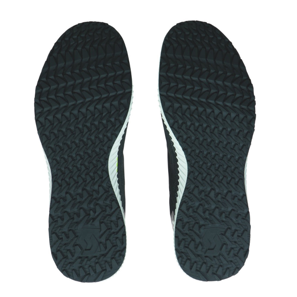A pair of black Scott Cruise training shoe soles with a herringbone tread pattern and brand logo visible.