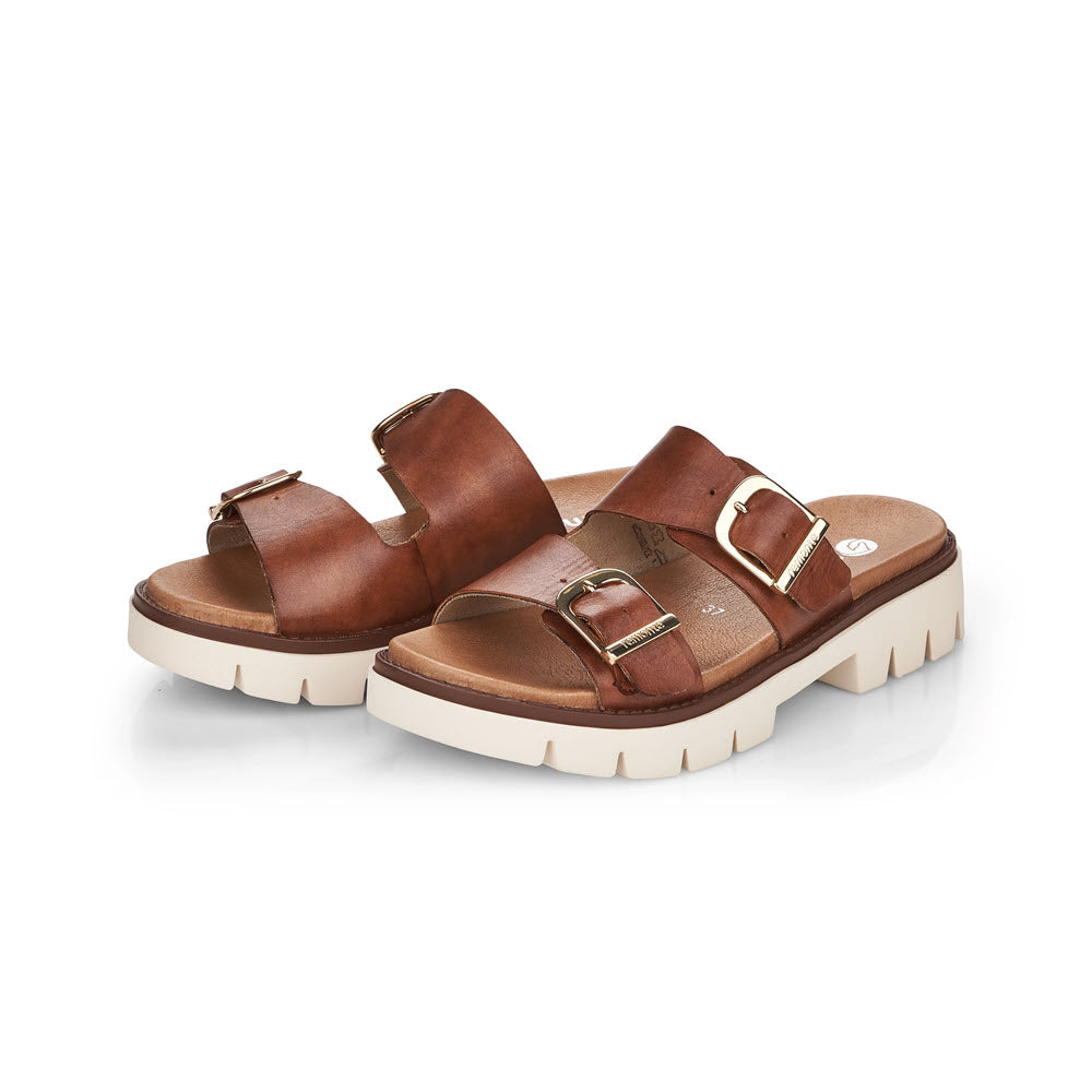 A pair of Remonte Chunky Sole Slide Brown sandals with buckle details and white soles on a white background.