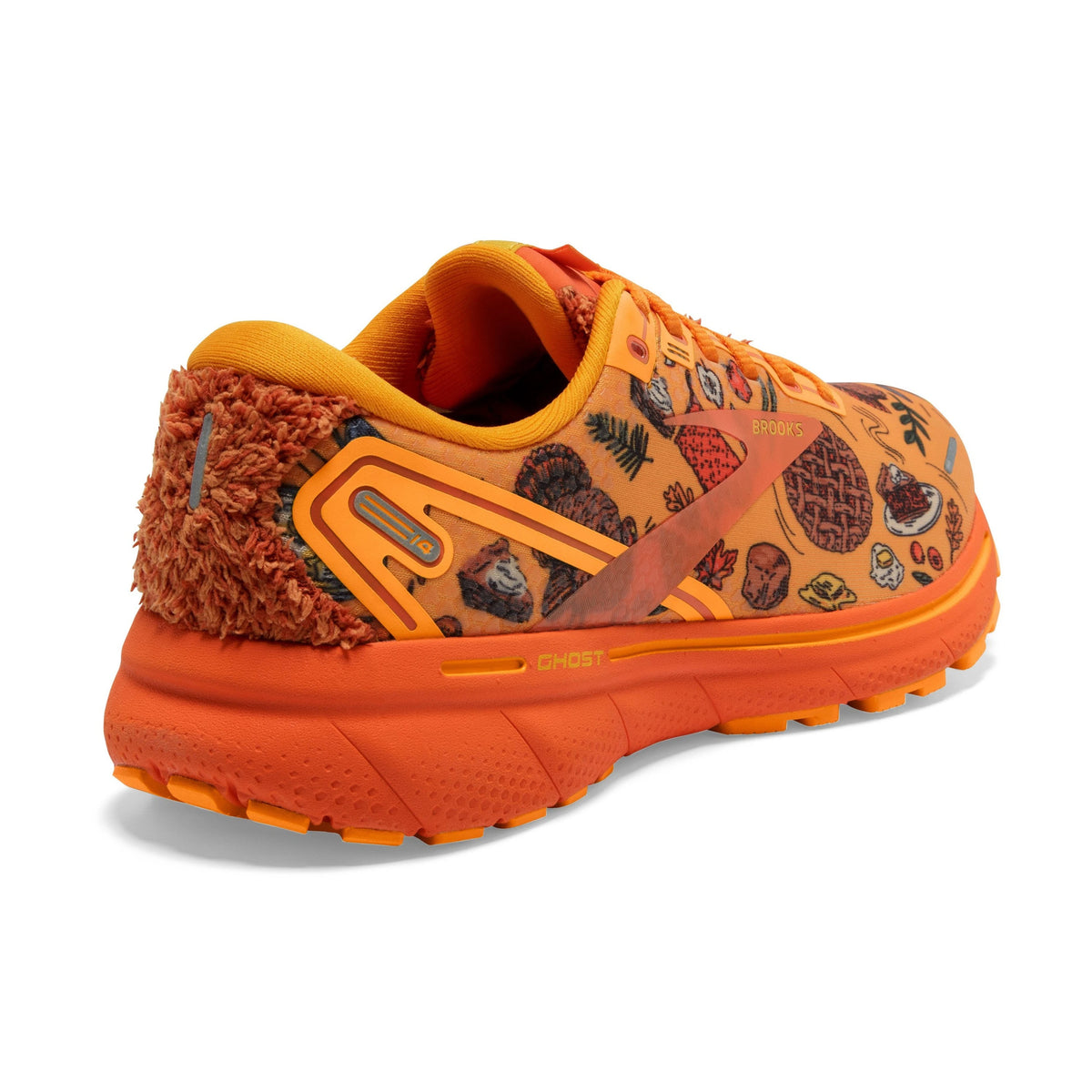 A colorful Brooks Ghost 14 Citrus/Gold Flame/Orangeade women&#39;s running shoe with illustrated designs and a furry ankle liner.