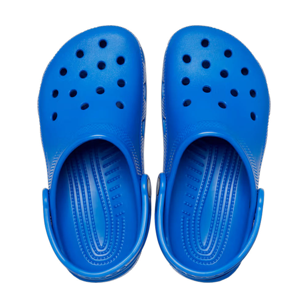 A pair of blue Crocs Classic Clogs with round ventilation holes, displayed on a white background, viewed from above.