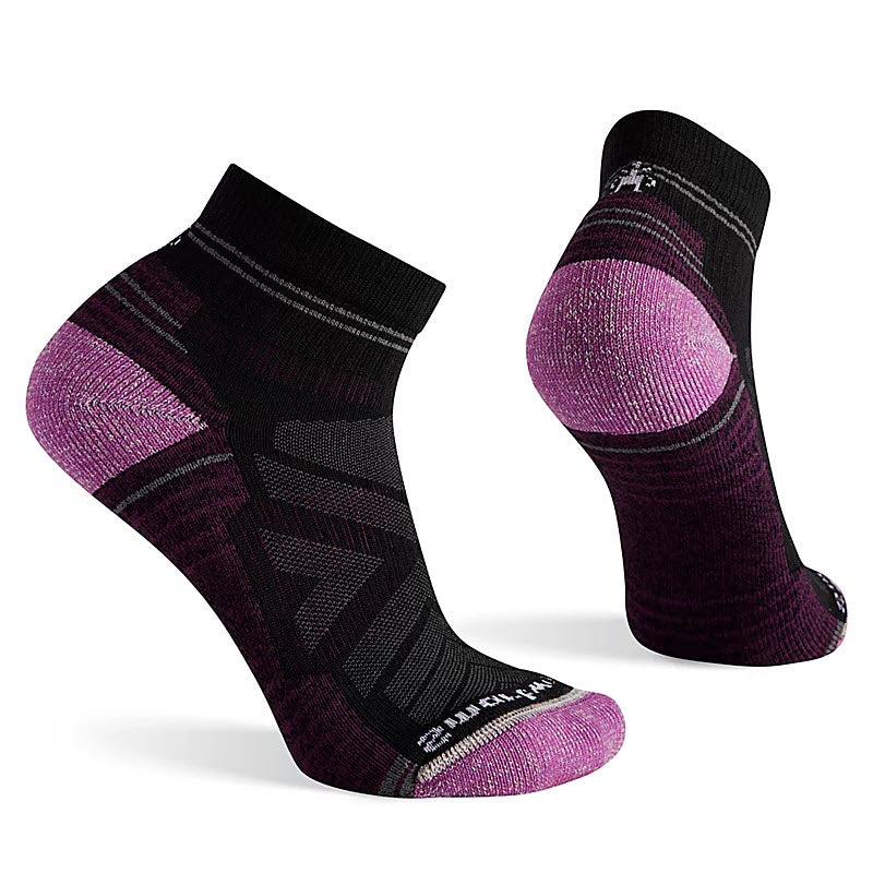 A pair of Smartwool women&#39;s purple and black hiking socks with light cushioning, displayed against a white background.