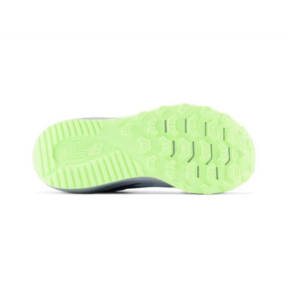 Sole of a New Balance kids&#39; running shoe with a detailed green tread pattern, featuring grooves and textured designs for grip.