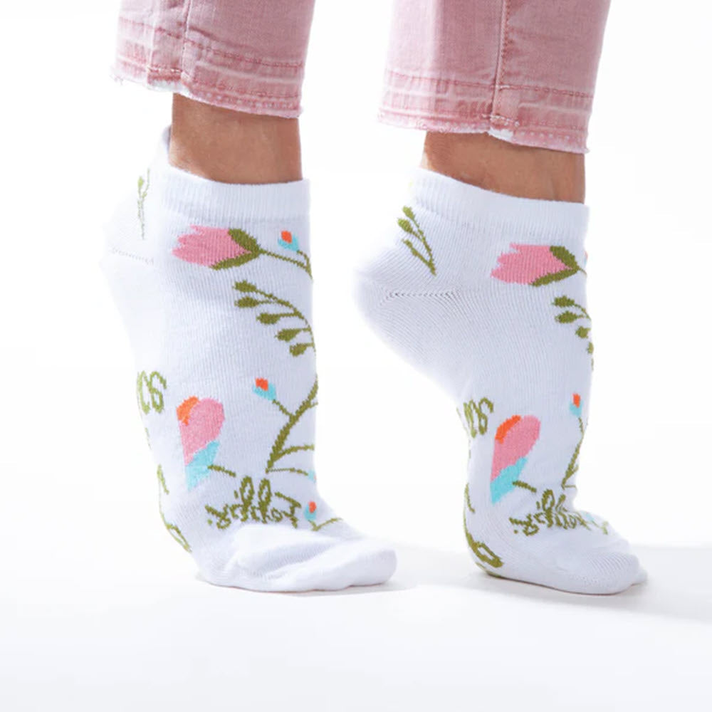 A person, part of the Worlds Softest partnership, wearing WORLDS SOFTEST YOU WERE CREATED LOW CUT SOCKS with a floral pattern standing against a white background.