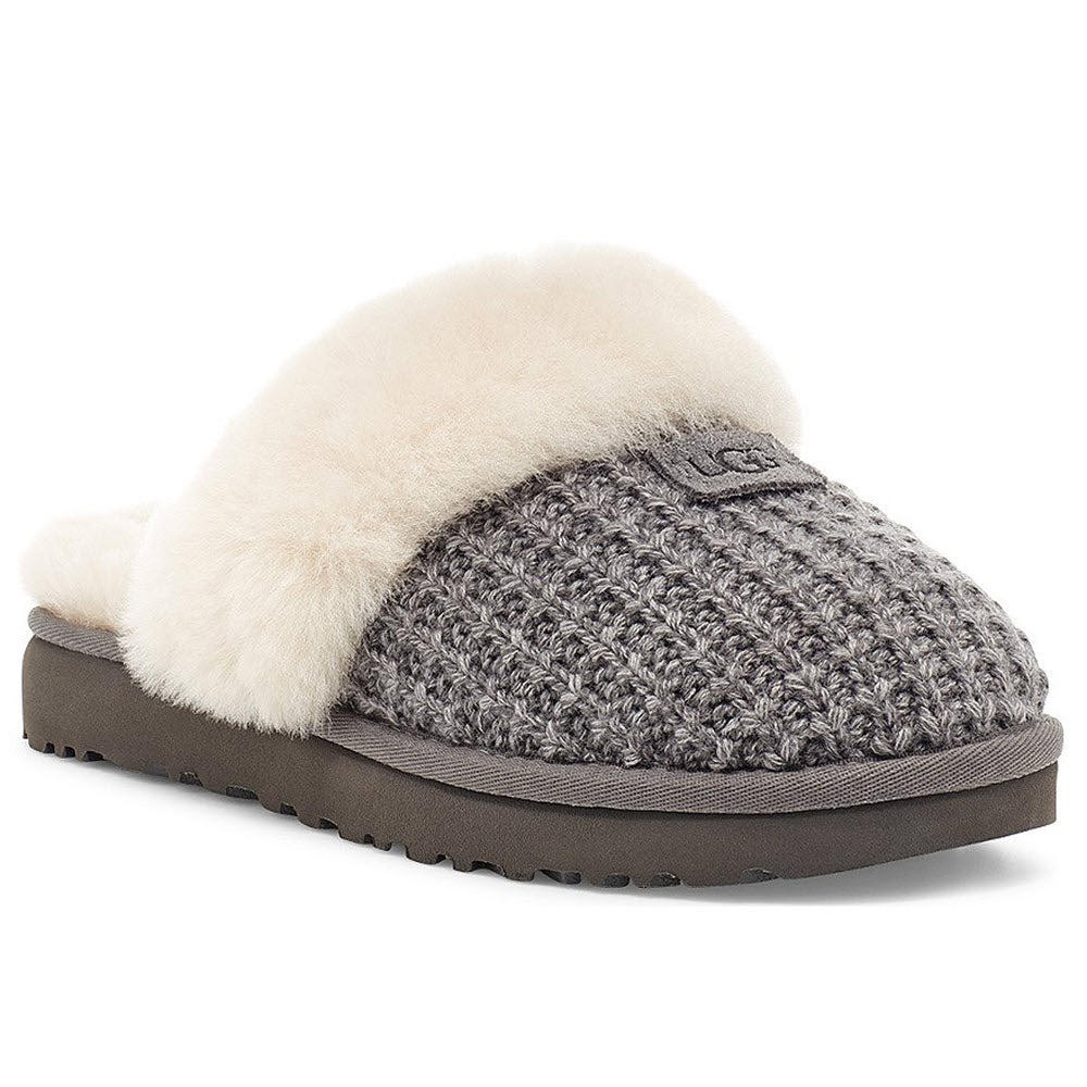 A Ugg COZY KNIT CHARCOAL slipper with a grey knitted upper and a fluffy cream-colored sheepskin collar on a white background.