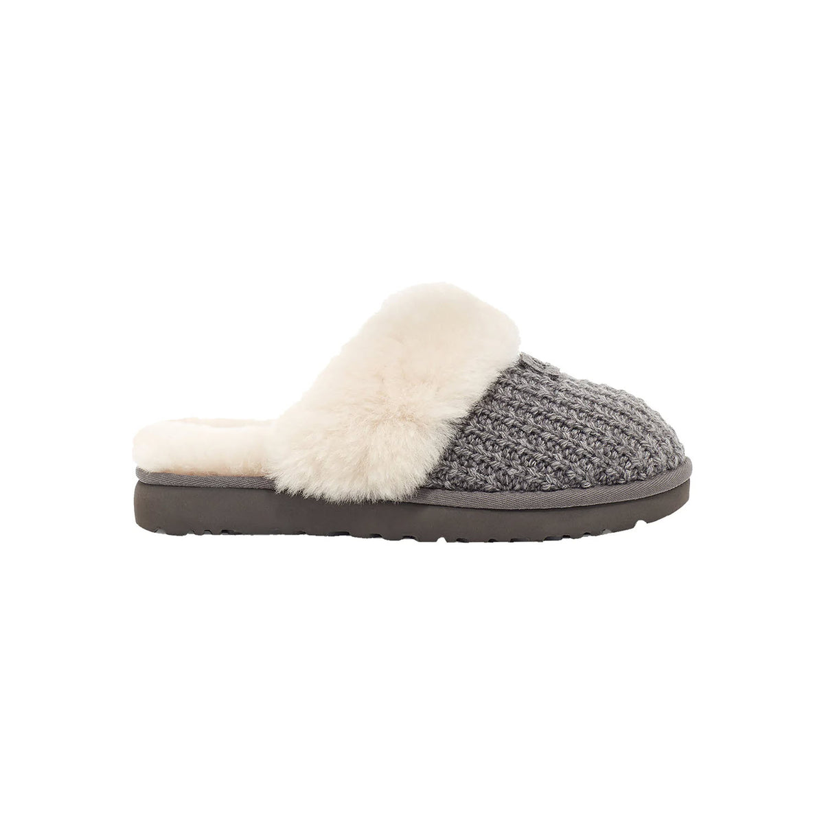A gray knitted UGG Cozy Knit Charcoal women&#39;s slipper with a plush white sheepskin collar and a dark rubber sole, displayed against a white background.