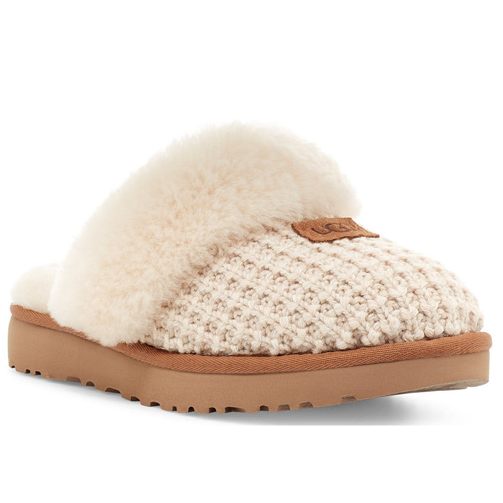 A UGG COZY KNIT CREAM - WOMENS slipper with a fluffy sheepskin lining and a rubber sole.