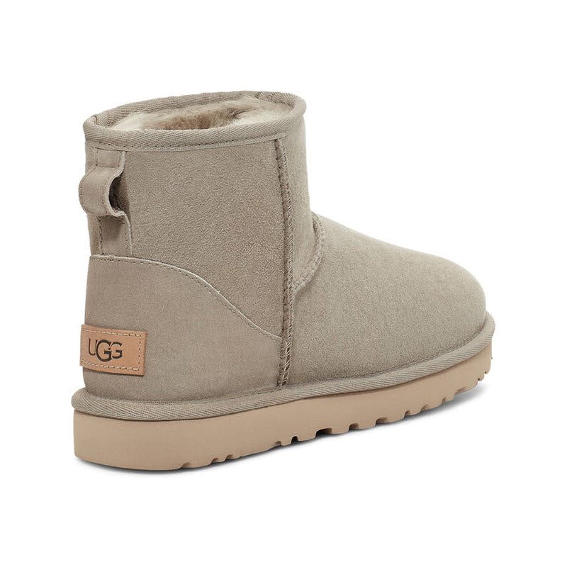 Beige sheepskin-lined ankle boot with brand label on the heel, UGG Classic Mini II Goat - Womens.