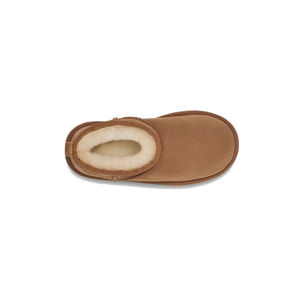 A single brown slipper with a soft, UGGplush™ insole and fluffy sheepskin lining. 
becomes
A single brown slipper with a soft, UGGplush™ insole and fluffy sheepskin lining from the Ugg CLASSIC ULTRA MINI CHESTNUT - KIDS.