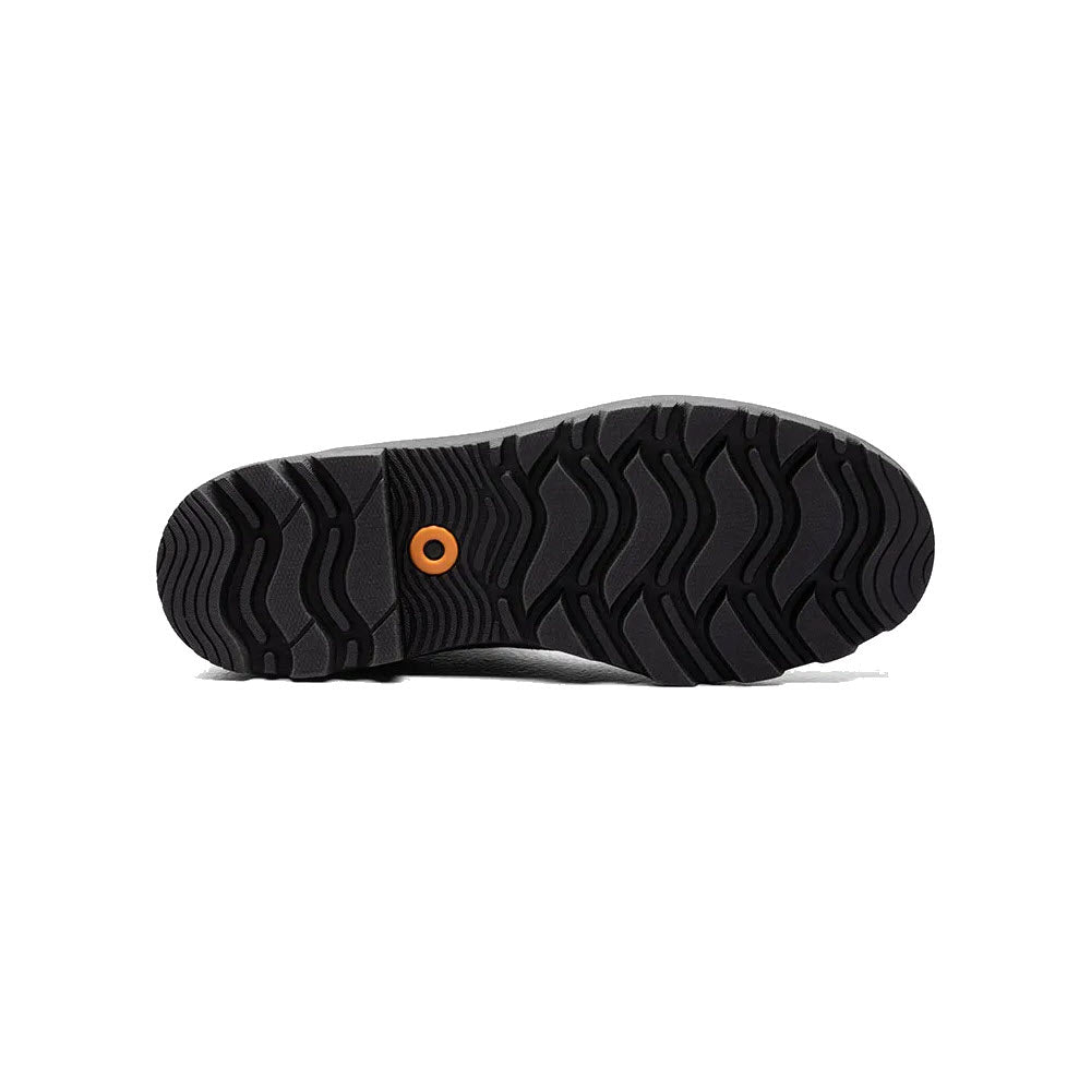 A close-up view of the black treaded Bogs sole of a shoe with a distinctive orange circular detail in the center. This versatile Bogs footwear is designed for both style and durability.
