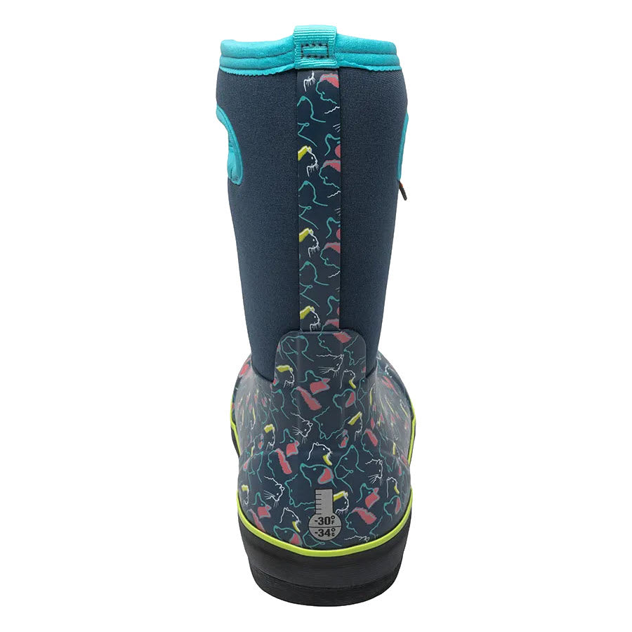Rear view of a child&#39;s blue neoprene Bogs Kids Classic II Pets Ink Blue Multi boot with a colorful dinosaur pattern and teal trim, featuring a buckle at the top.