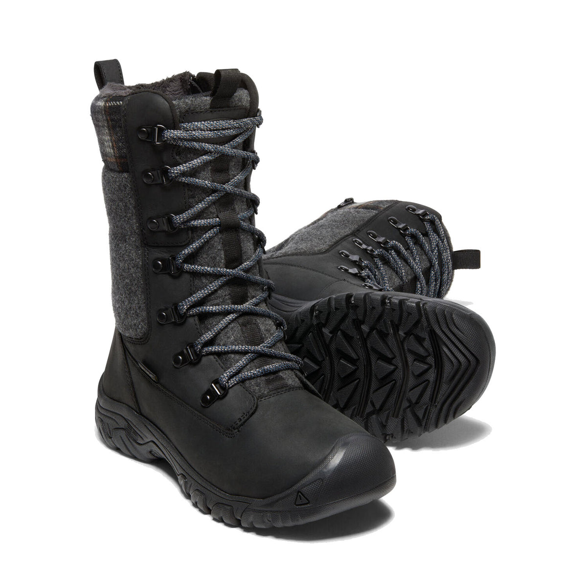 A pair of Keen KEEN GRETA TALL BOOT WP BLACK - WOMENS, featuring a KEEN.DRY membrane and black lace-up design with gray wool detailing on a white background.