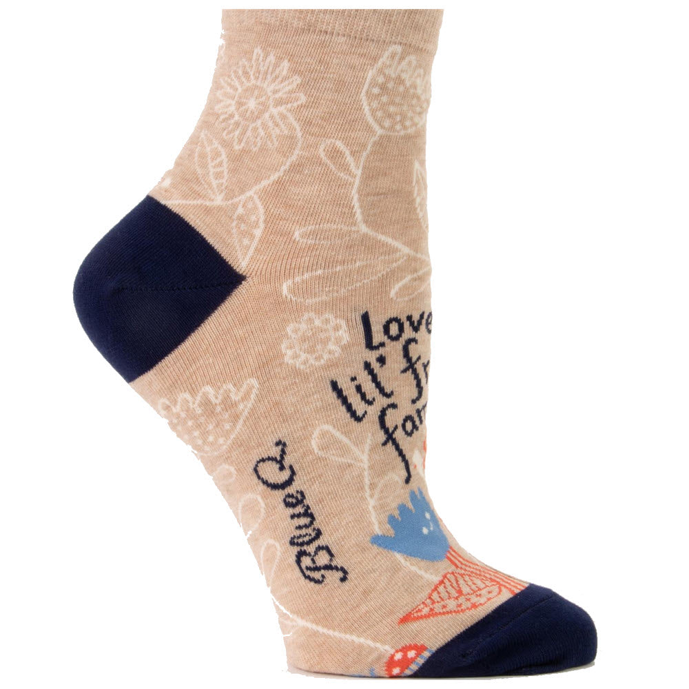 A Blue Q ankle sock with floral designs and motivational text, predominantly in beige with navy accents, fits women&#39;s shoe size 5-10.