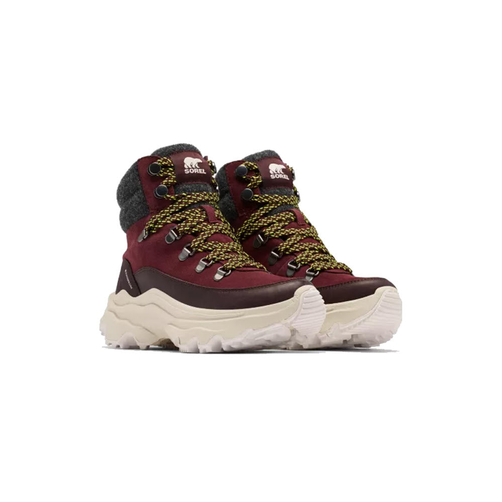 A pair of red SOREL Kinetic Breakthru Conquest WP winter boots with grey trim and chunky white soles, offering waterproof protection.