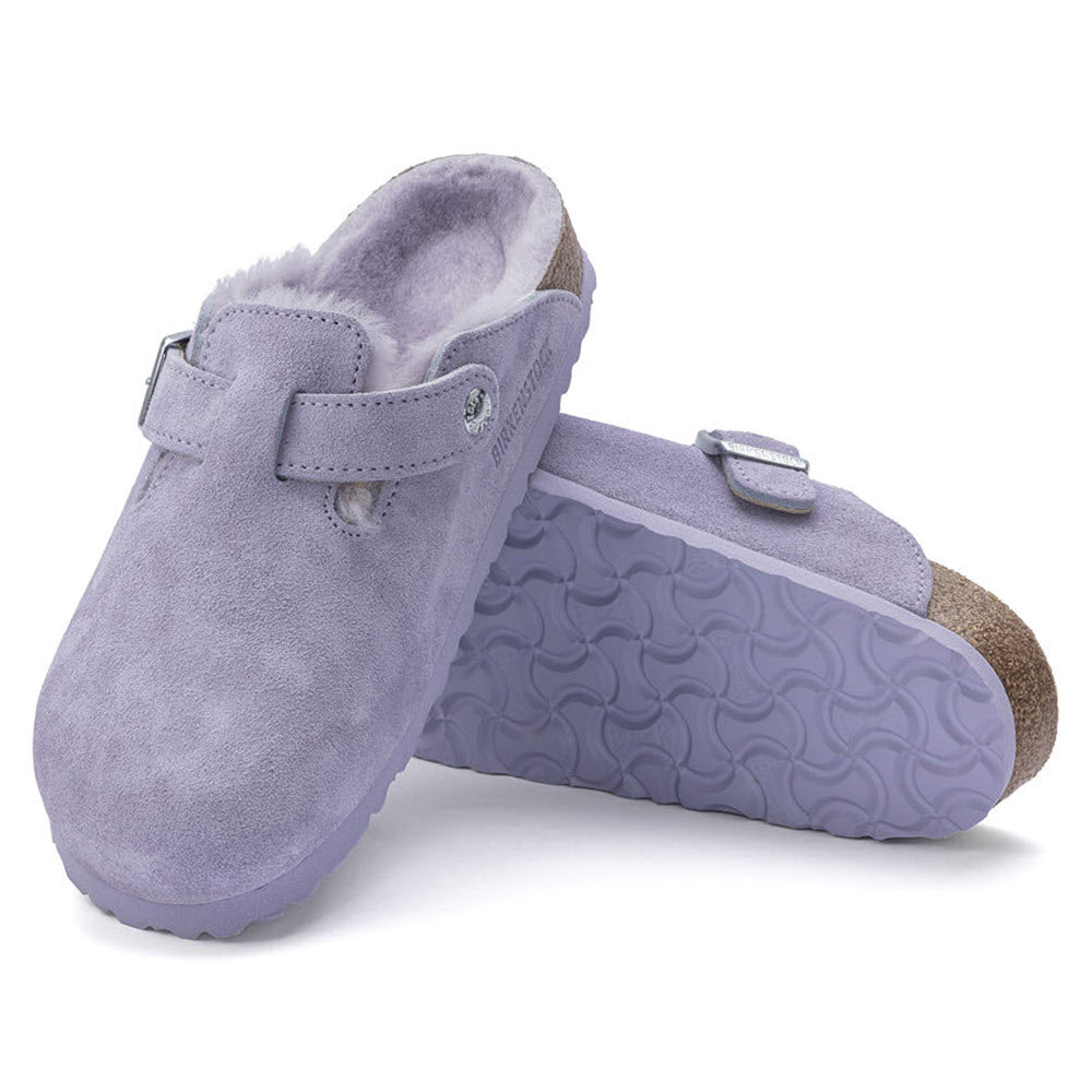A pair of purple suede Birkenstock Boston shearling purple fog clogs with buckle straps and contoured rubber soles, isolated on a white background.