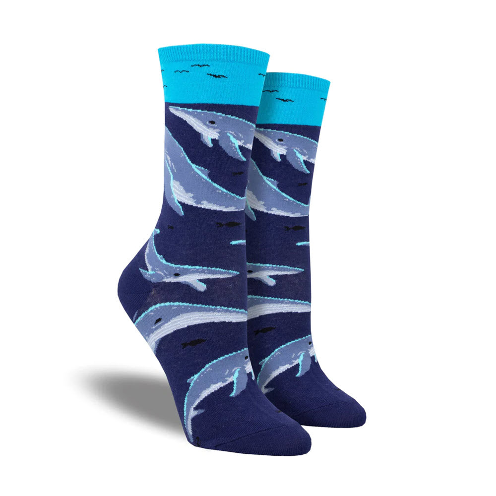 A pair of SOCKSMITH WHALE WATCHING NAVY crew socks, with a blue whale pattern design, isolated on a white background.