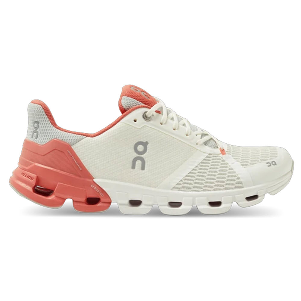 A white and coral On Running Cloudflyer athletic shoe with a distinctive CloudTec® sole design.