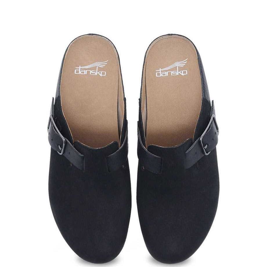 A pair of black Dansko Caia casual mule clogs displayed against a white background.