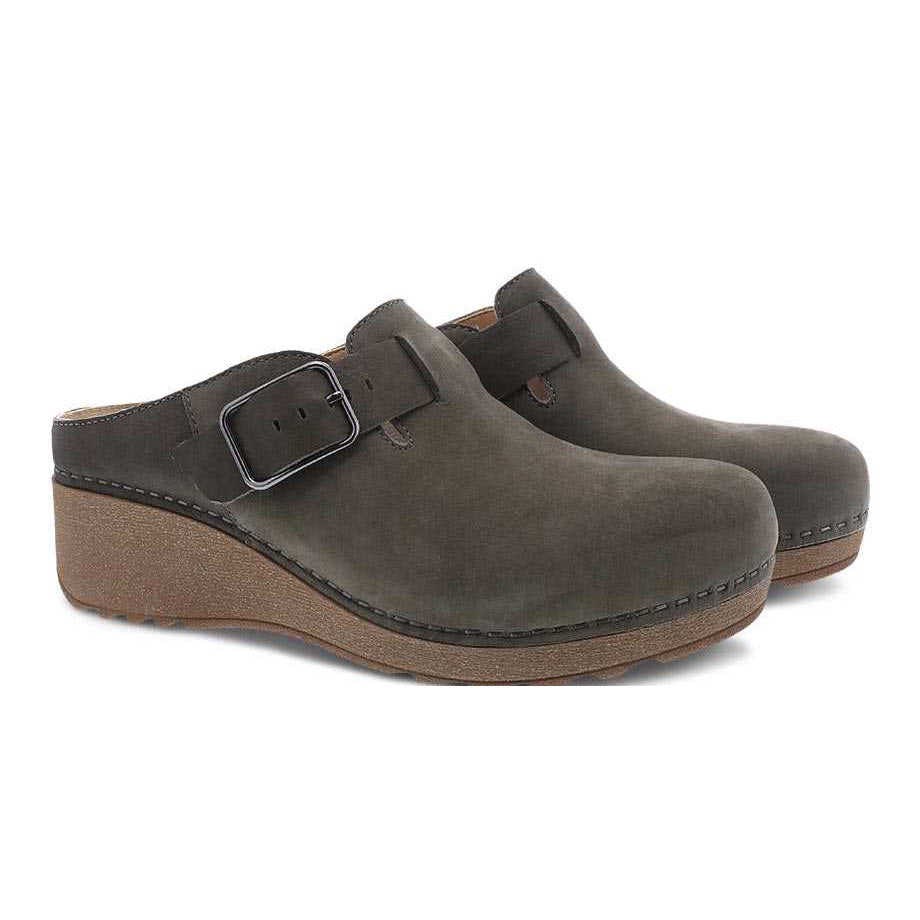 A pair of dark gray Dansko Caia Taupe Milled casual mule clogs with buckle detail and wooden soles.