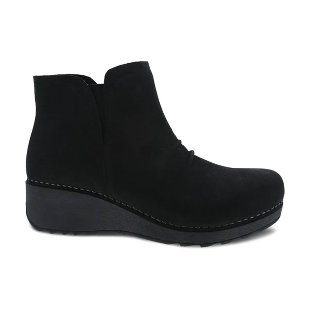 Dansko black nubuck leather ankle boot with a low wedge heel and visible stitching, displayed against a white background.