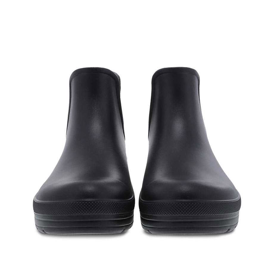 A pair of black Dansko Karmel Rain boots isolated on a white background.