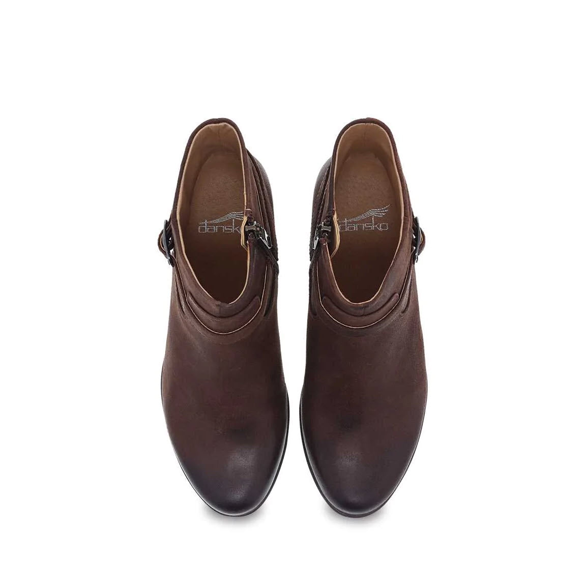 A pair of dark brown leather loafers with zippers and Dansko Natural Arch support, viewed from the top on a white background.