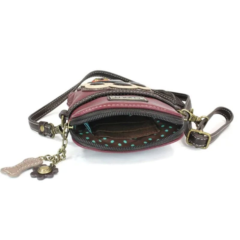 Small, open maroon Chala Venture Phone Crossbody Paw Bag with polka-dot lining and decorative keychain, isolated on a white background.