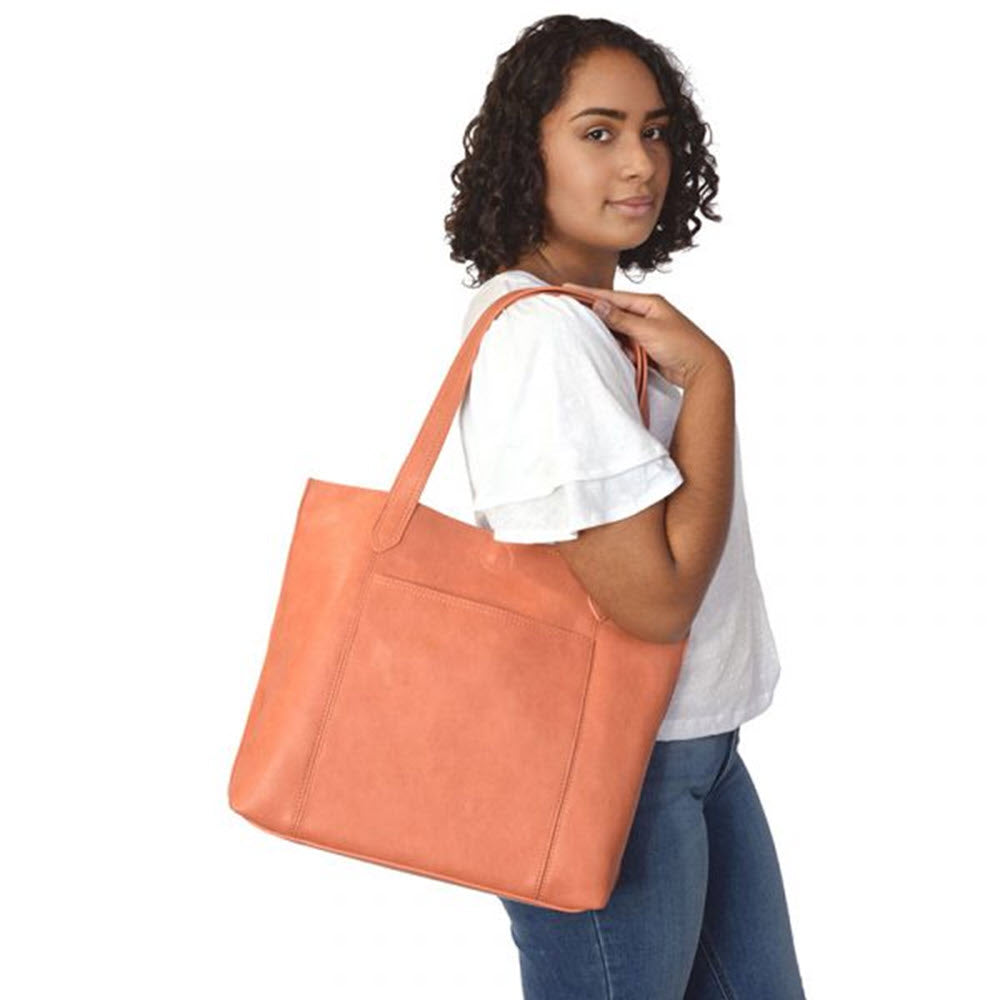 Woman posing with an oversized JOY SUSAN TAYLOR TOTE BAG CORAL featuring a tan Antiqued Vegan Leather shoulder bag.