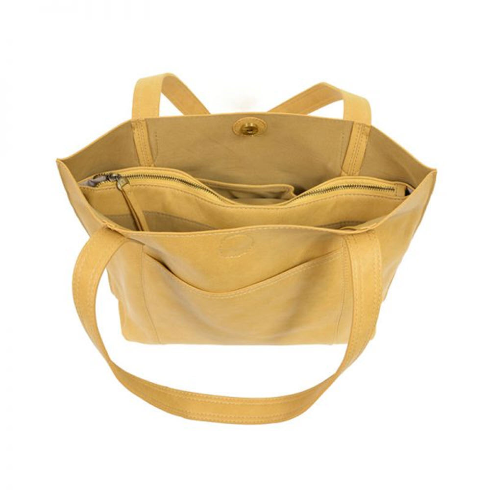 Mustard yellow oversized Joy Susan Taylor tote bag in antiqued vegan leather with top button closure and roomy interior including an internal zipper pocket.