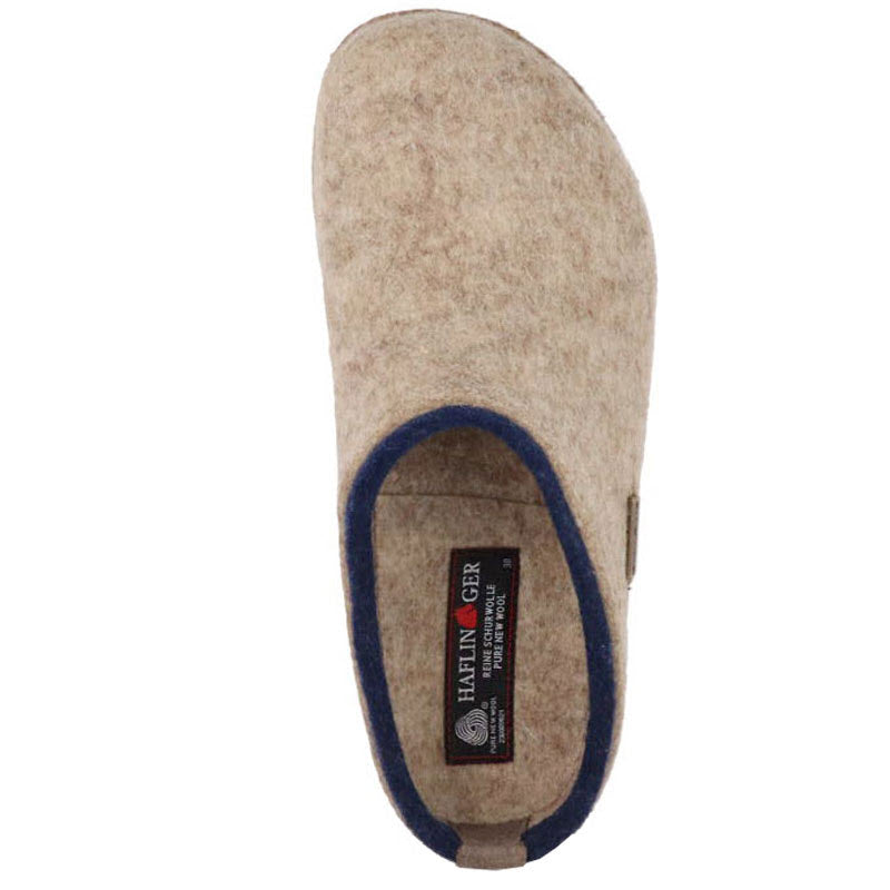 Top view of a beige boiled wool felt slipper with a blue trim and a Haflingers label inside.