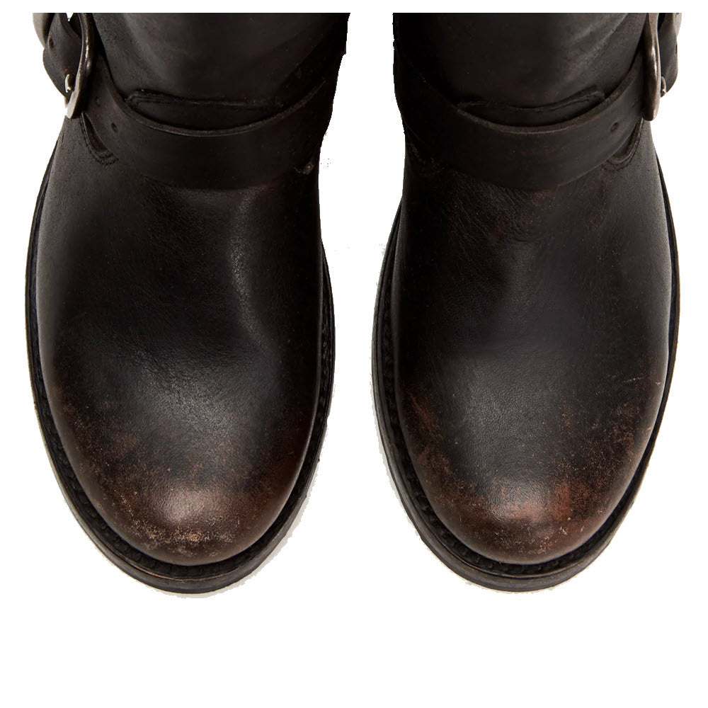 Close-up of worn black Frye Veronica Short Black Distressed leather boots with scuff marks on white background.