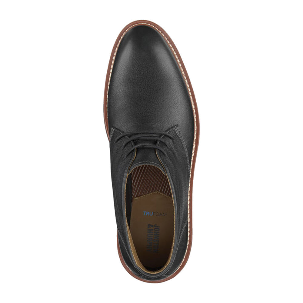 Top view of a Johnston &amp; Murphy Upton Chukka Black Full Grain dress shoe with dark laces and brown stitching, featuring a TRUFOAM™ sole, on a white background.