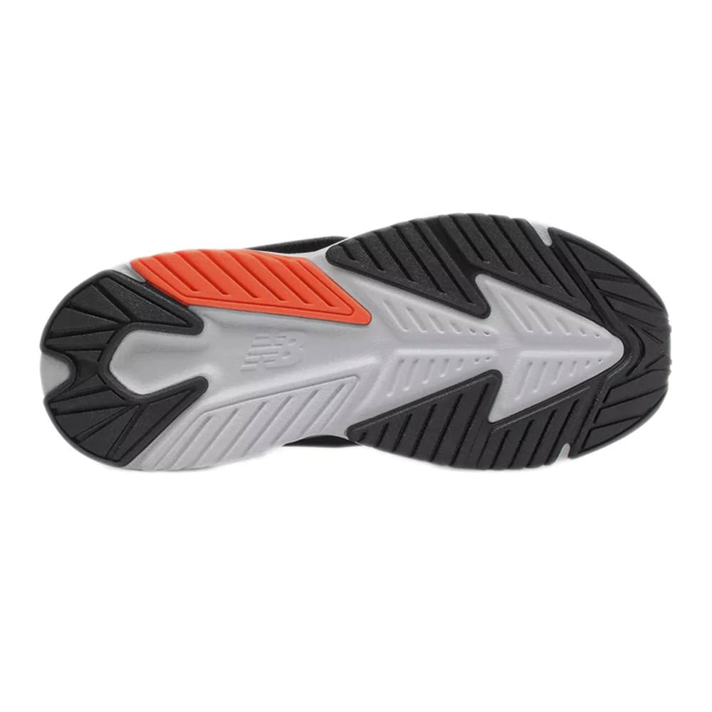 A close-up of the sole of a NEW BALANCE RAVE RUN HOOK &amp; LOOP BLACK - KIDS kids&#39; running shoe with black, orange, and white detailing.