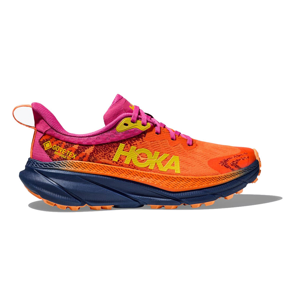 Bright orange and pink Hoka Challenger 7 GTX trail running shoe with prominent logos and a blue sole, featuring a rugged tread pattern for grip.