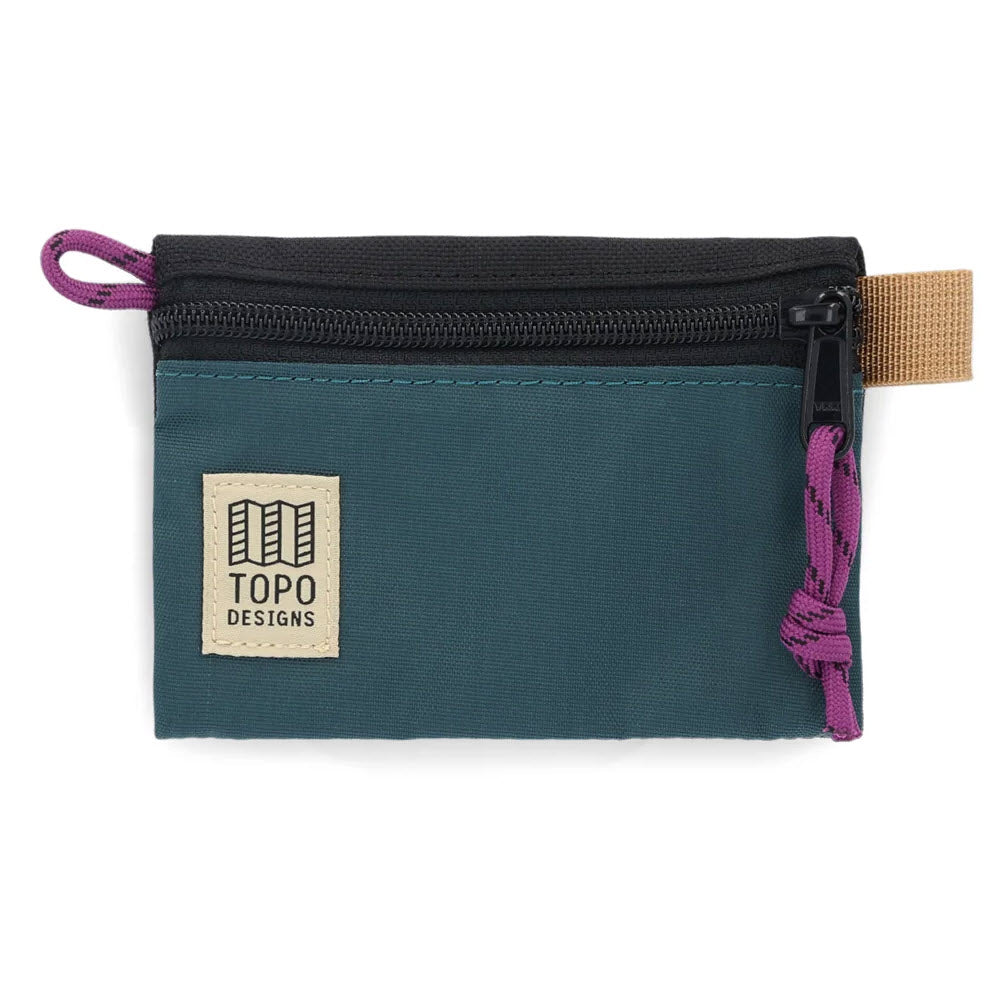 A small, teal Topo Designs zippered accessory bag with a purple zipper pull and a tan logo patch.