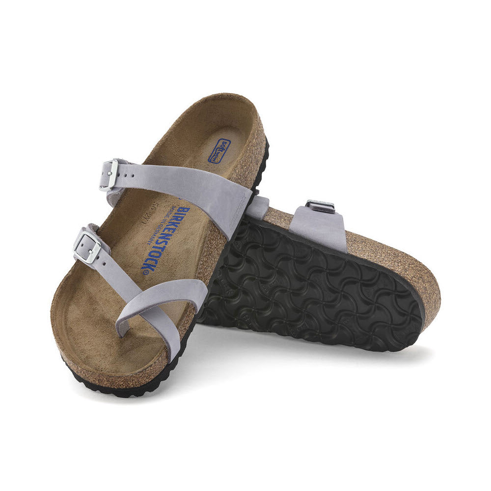 A pair of Birkenstock Mayari Purple Fog Nubuck sandals with buckles, featuring a cork sole and soft footbed, isolated on a white background.