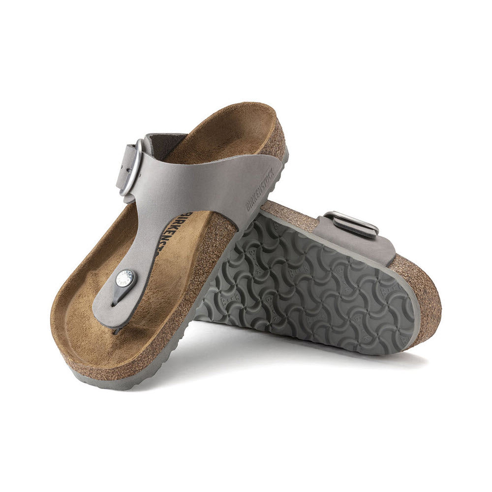 A pair of Birkenstock Gizeh Big Buckle Dove Grey Nubuck sandals with buckles, showcased against a white background.