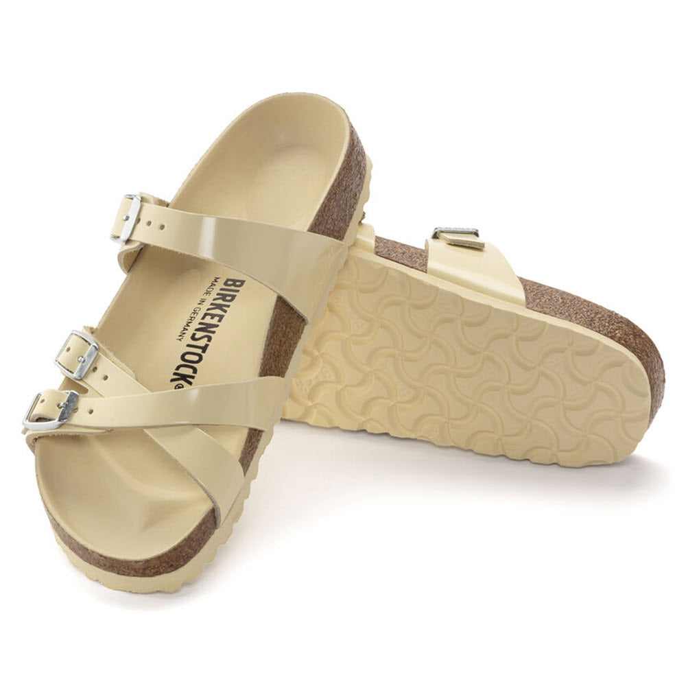 A pair of natural leather Birkenstock Franca Hex High Shine Butter sandals with adjustable straps on a white background.