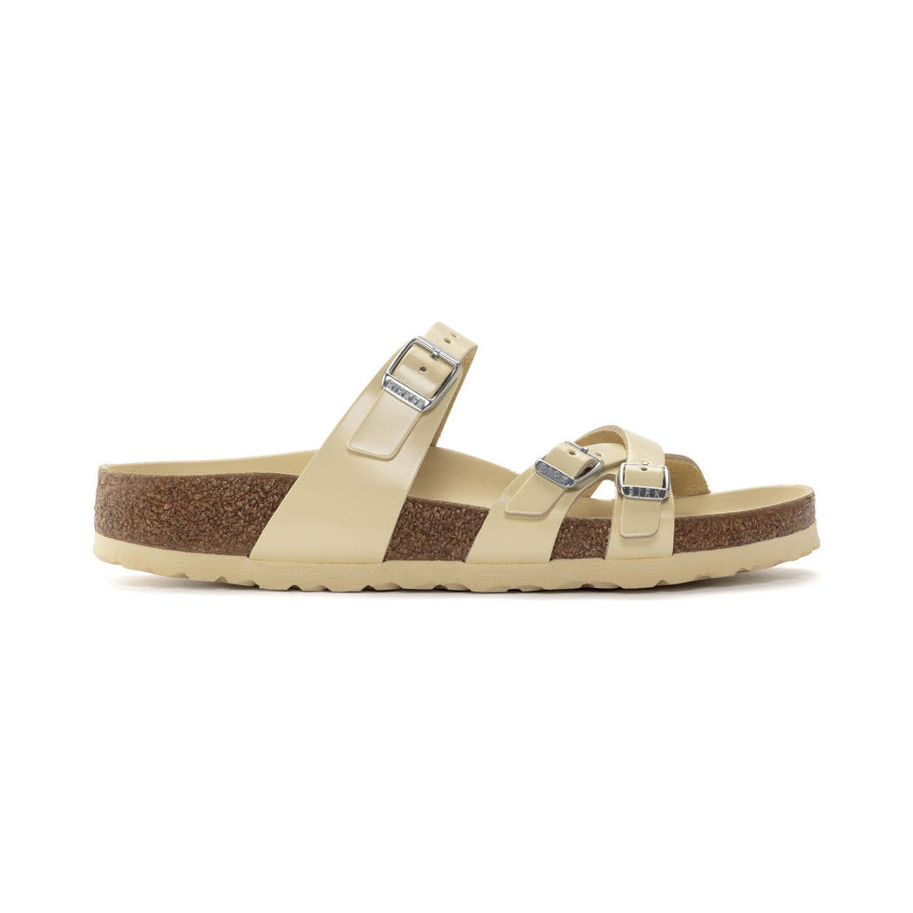 A pair of light beige Birkenstock FRANCA HEX HIGH SHINE BUTTER sandals with two buckle straps and a contoured cork-latex footbed, isolated on a white background.