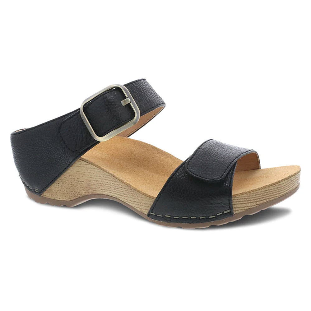 A single Dansko Tanya Black leather upper women&#39;s sandal with a buckle strap and a wooden base, displayed on a white background.