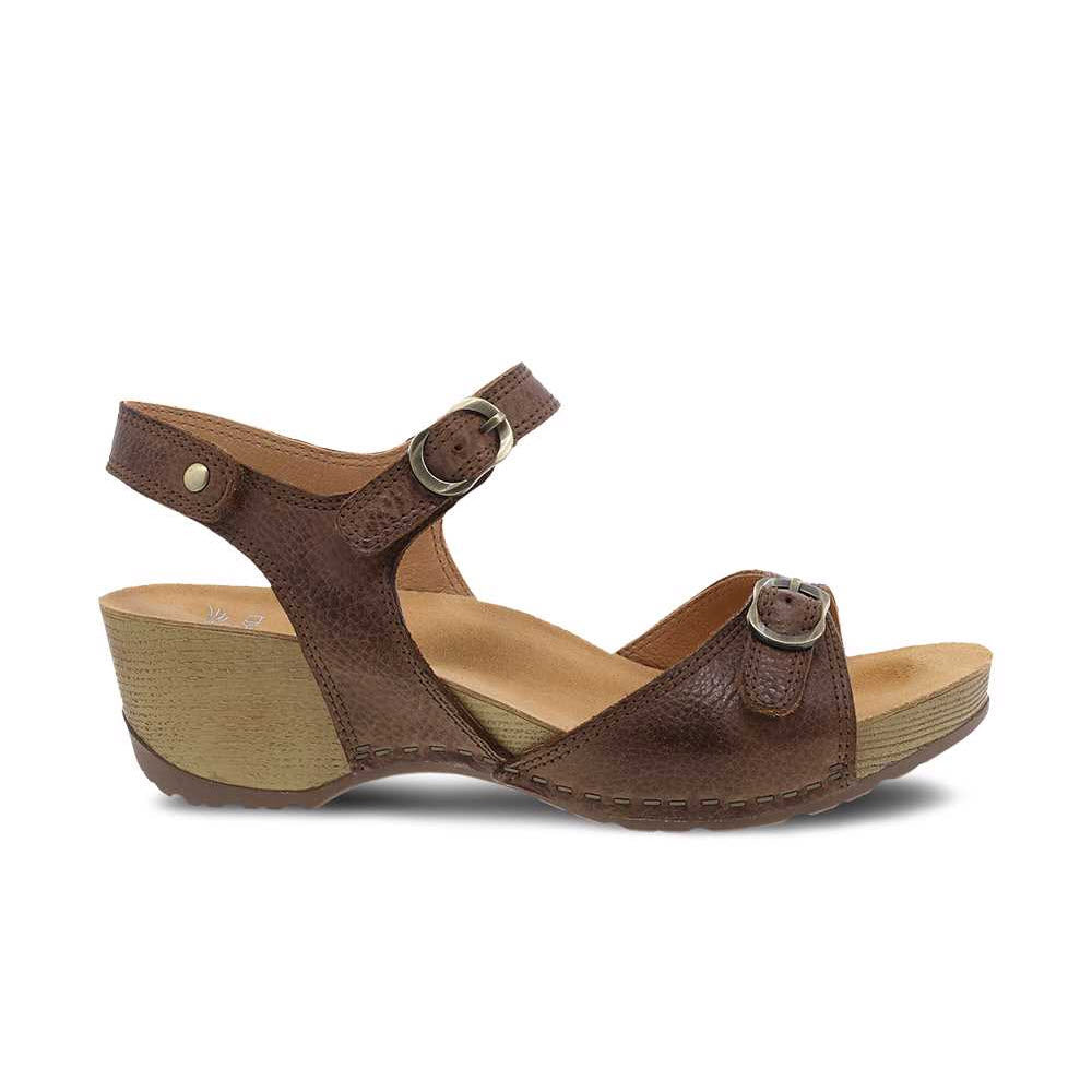 Dansko Tricia brown burnished leather wedge sandal with adjustable straps against a white background.