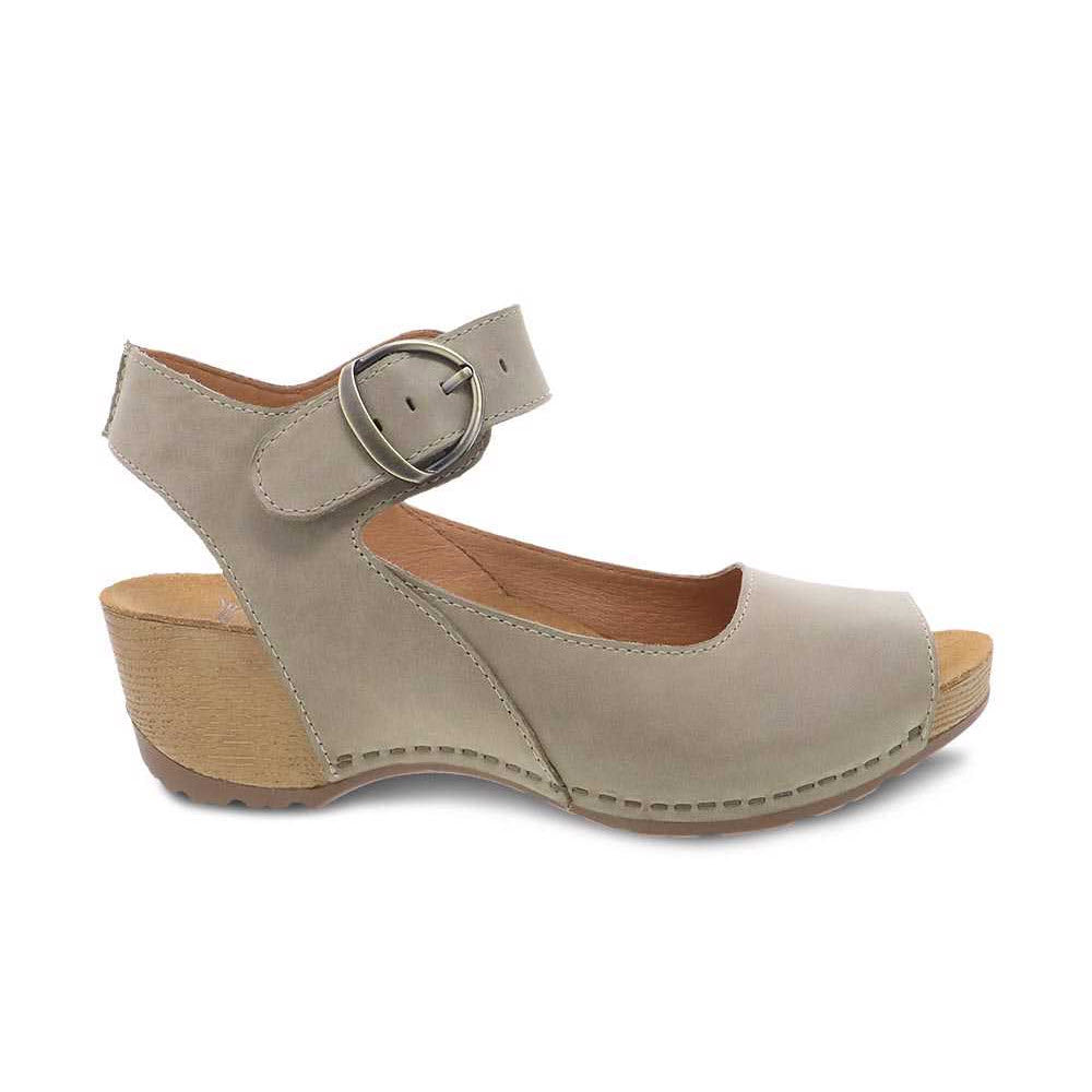 A khaki nubuck leather mary jane style shoe with a buckle and wooden sole, isolated on a white background.