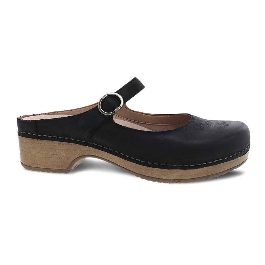 Dansko Bria black nubuck mule with an ankle strap, wooden sole, and visible stitching, isolated on a white background.
