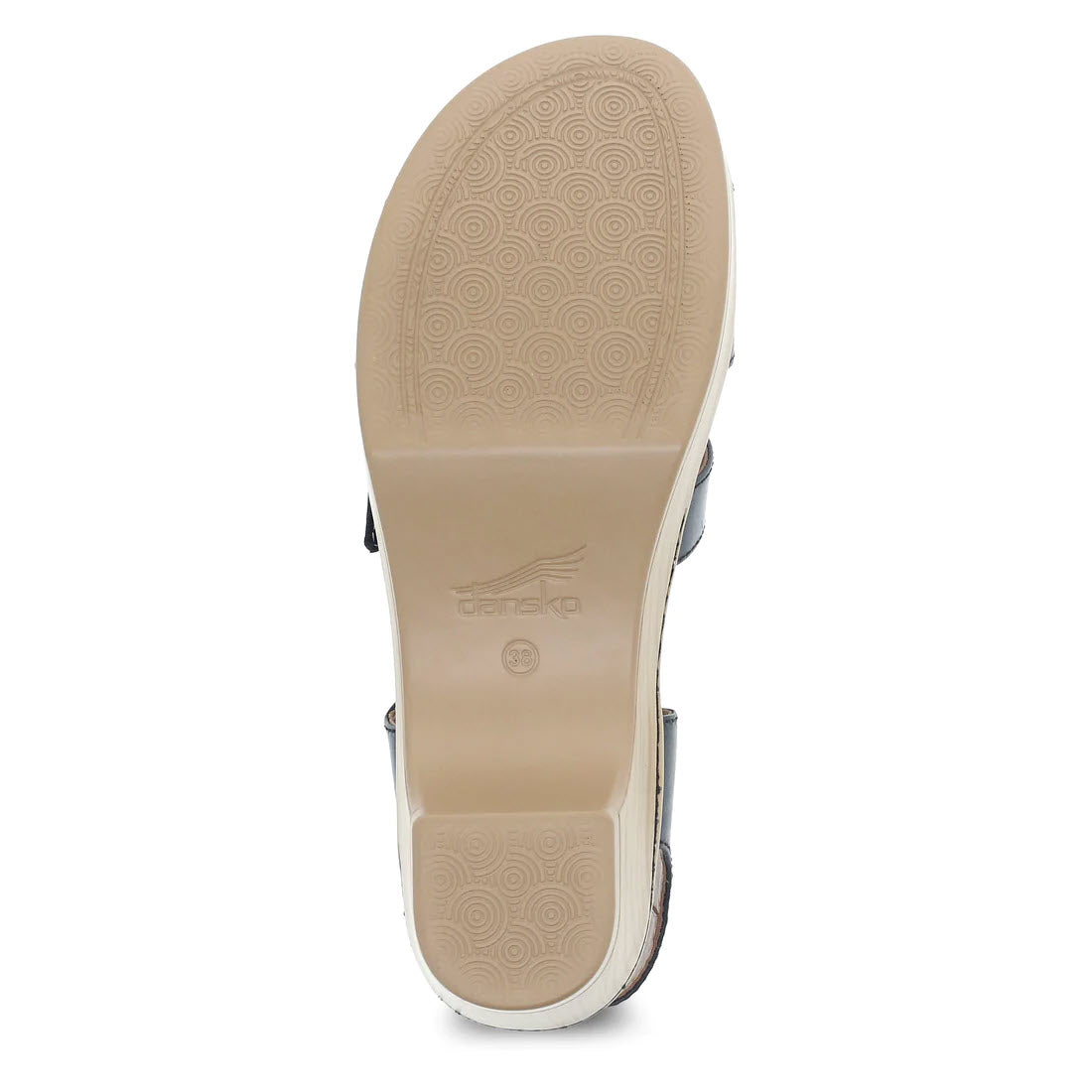 Sole of a sandal with tan rubber tread featuring circular patterns and the brand logo &quot;Dansko&quot; embossed in the center, complemented by a leather-wrapped EVA footbed.