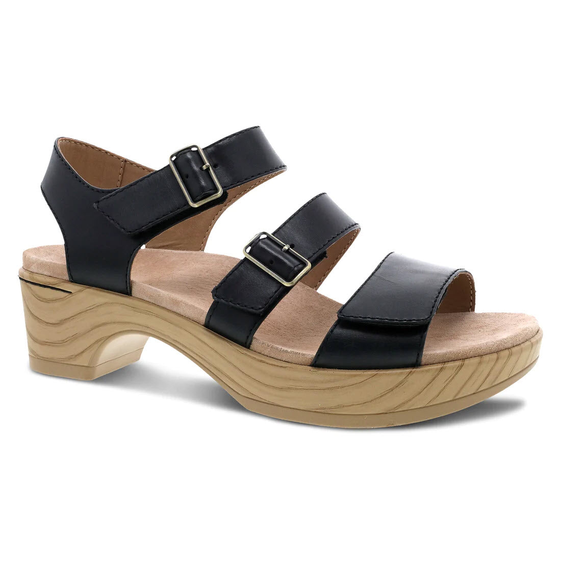 Dansko Malena black triple strap sandals with buckles, featuring a chunky wooden heel and a light-colored sole.