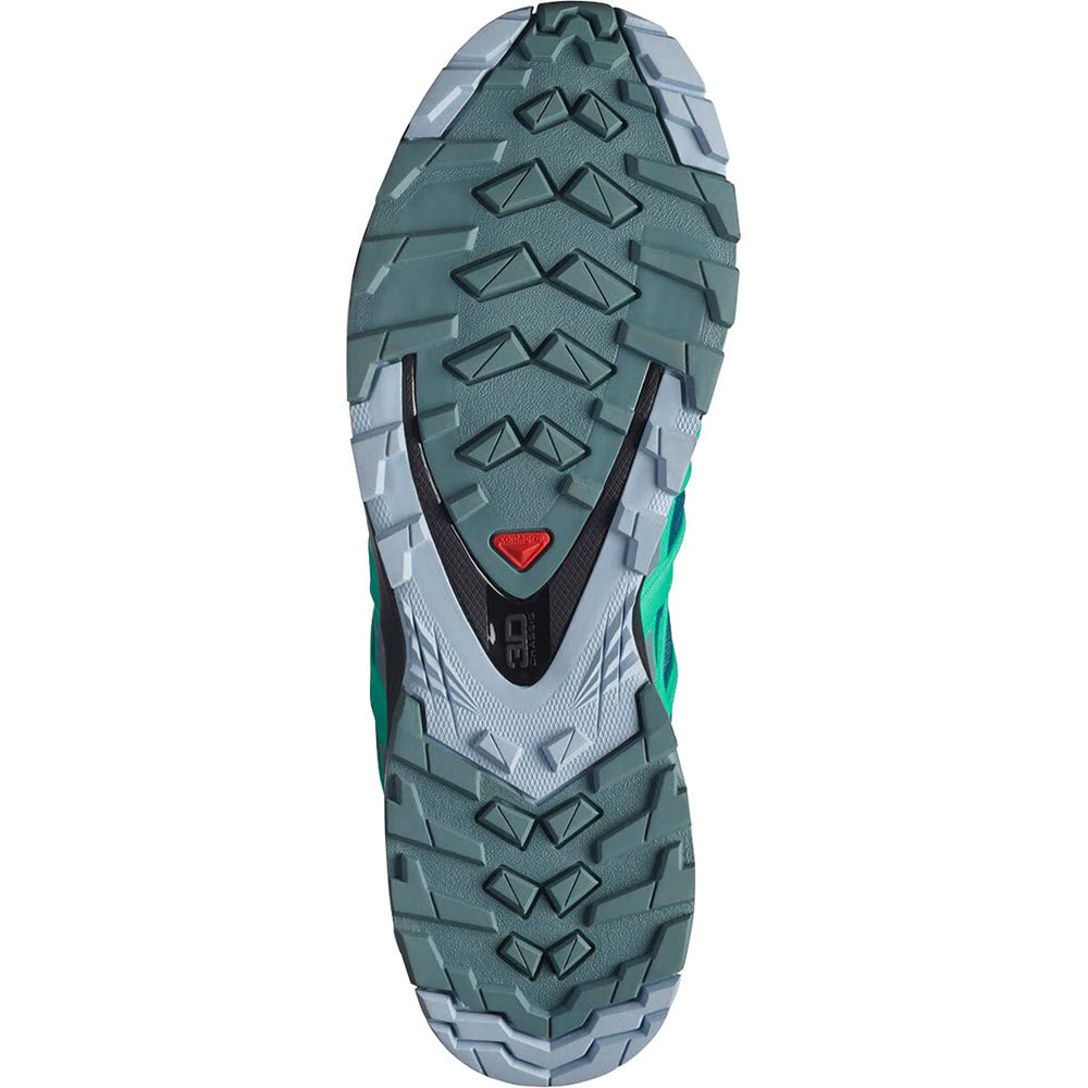 Bottom view of a Salomon XA Pro 3D V8 GTX Legion Blue trail running shoe featuring a GORE-TEX membrane, with a green and black tread pattern and a triangular red logo in the center.