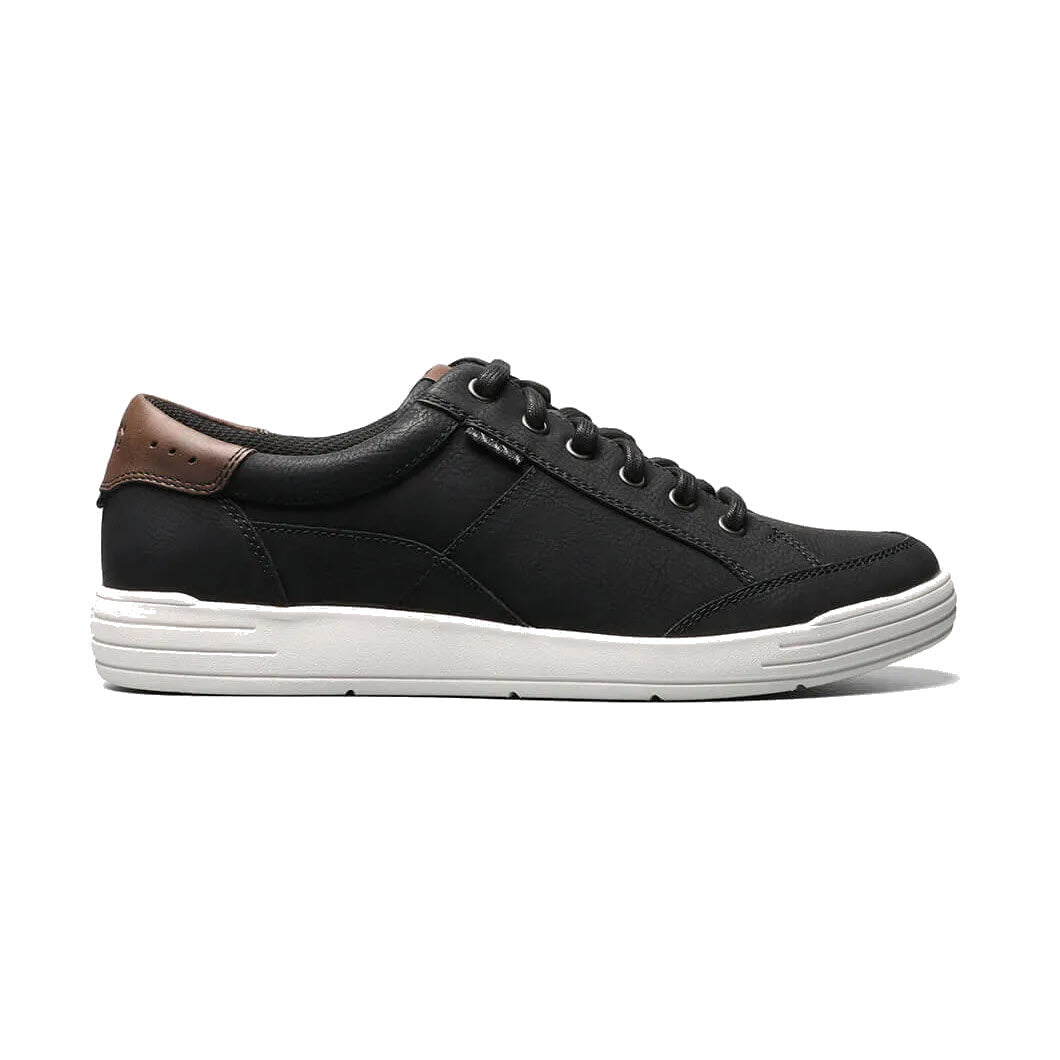 A Nunn Bush black leather sneaker with a white sole and brown leather detailing on the heel, featuring a Comfort Gel footbed, displayed against a white background.
