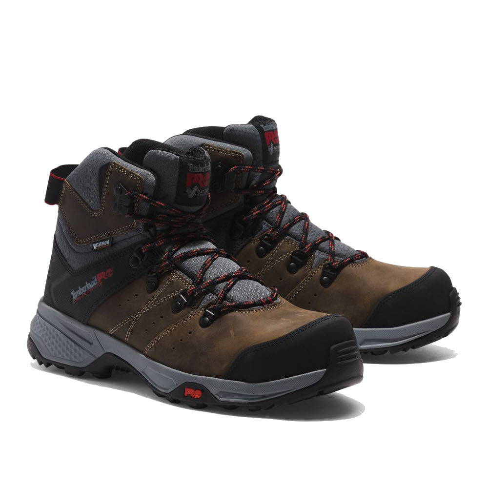 A pair of Timberland men&#39;s work boots in brown with black and red accents, featuring lace-up fronts, robust soles, and composite safety toes.