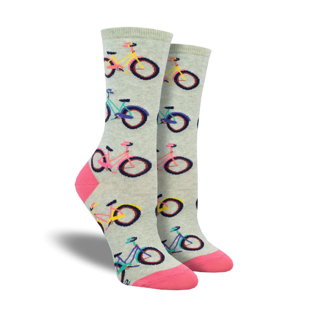 A pair of Socksmith Coastal Cruiser crew socks in mint with a colorful bike pattern on a light gray background, featuring pink toe and heel patches.